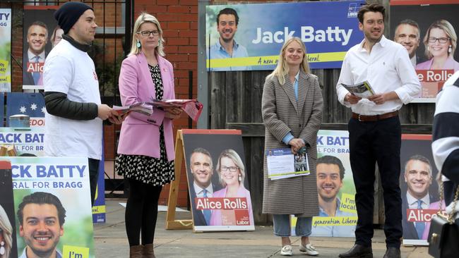 Bragg candidates Alice Rolls, (pink jacket) and Jack Batty (white shirt) with wife Charlotte,(long grey coat) at the Glenunga High School on 2 July 2022. Picture Dean Martin