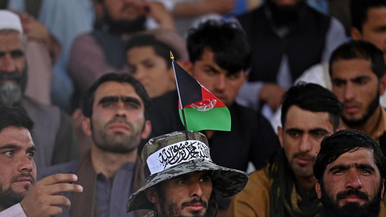 A spectator wearing a hat with an Afghanistan flag and Taliban ribbon watches the Twenty20 cricket trial match being played between two Afghan teams 'Peace Defenders' and 'Peace Heroes' at the Kabul International Cricket Stadium in Kabul on September 3, 2021. (Photo by Aamir QURESHI / AFP)