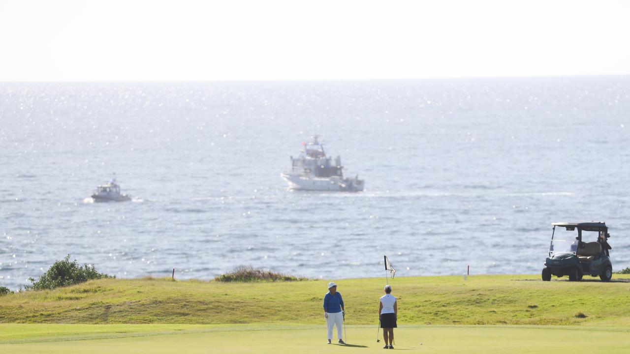 People watch as NSW fisheries and police along with life savers turn up early to search for remains at Little Bay after a shark attack. Picture John Grainger