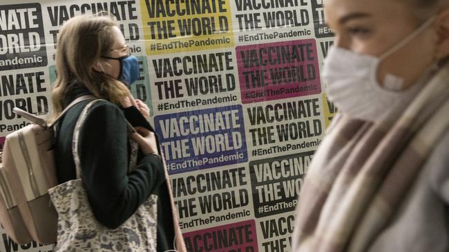 Members of the public walk past a Covid-19 inspired poster on London's underground in London, England. Picture: Getty Images