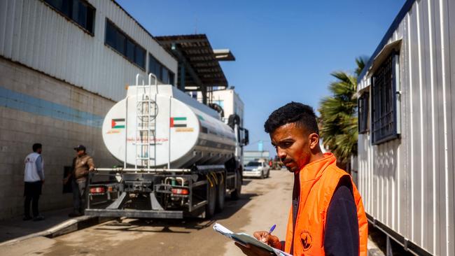 A worker takes notes as tanker trucks move to fill up water at the Southern Gaza Desalination plant, which stopped working earlier after Israel cut off electricity supply to the Gaza Strip. Picture: AFP