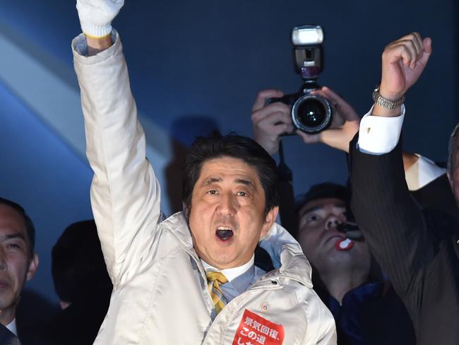 Japanese Prime Minister and ruling Liberal Democratic Party (LDP) leader Shinzo Abe (C) and party members gesture during election campaigning in Tokyo on December 13, 2014. Heavy snow hit large swathes of Japan on December 13, the eve of a general election, fuelling speculation the ruling coalition is on course to an easy victory on low voter turnout. AFP PHOTO / KAZUHIRO NOGI