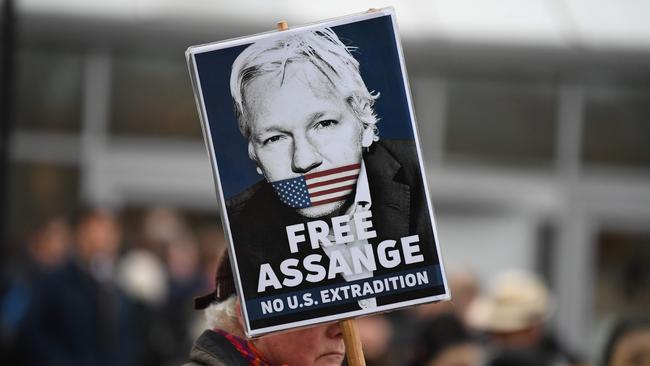 A supporter of WikiLeaks founder Julian Assange holds a placard calling for his freedom outside Woolwich Crown Court. Picture: AFP