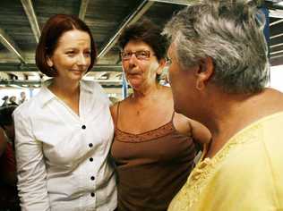 Prime Minister Julia Gillard comforts Grantham women Sue Elliot and Beryl Harm during a visit to the shattered community in January last year. Picture: Claudia Baxter