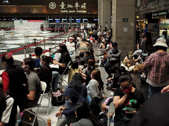 People queue up to receive the Medigen and Moderna vaccines for coronavirus at Taipei's main train station. Picture: AFP