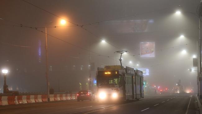 A tram ploughs through the thick fog. Picture: David Crosling