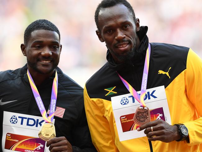 Gold medallist US athlete Justin Gatlin (L) and bronze medallist Jamaica's Usain Bolt pose on the podium during the victory ceremony for the men's 100m athletics event at the 2017 IAAF World Championships at the London Stadium in London on August 6, 2017.  / AFP PHOTO / Jewel SAMAD