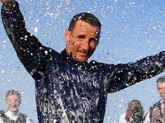 MELBOURNE, AUSTRALIA - NOVEMBER 11: Jockey Damien Oliver is sprayed with champagne after his final Flemington carnival during Stakes Day at Flemington Racecourse on November 11, 2023 in Melbourne, Australia. (Photo by Quinn Rooney/Getty Images)