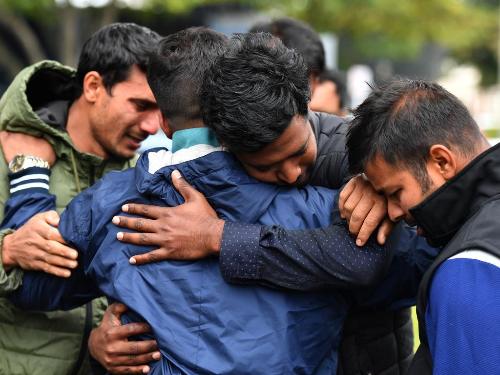 Friends of a missing man grieve outside a refuge centre in Christchurch on Sunday. Picture: AAP Image/Mick Tsikas 