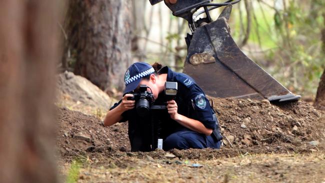 A NSW police officer photographs possible evidence during the search near where William Tyrrell went missing in Kendall in 2014. Picture: AAP