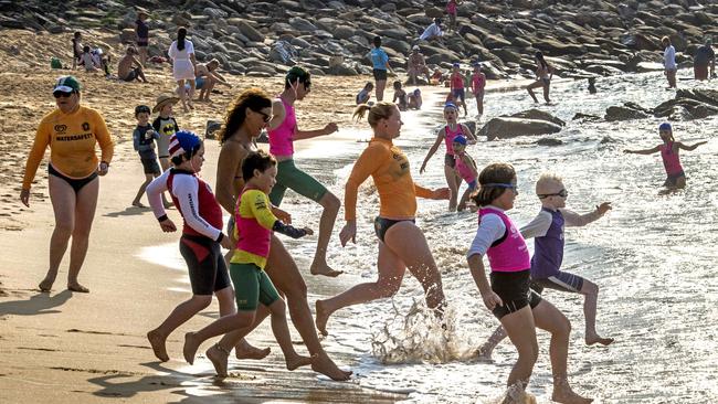 Competitors and assistants run to the water during the beach swim at the Surf Life Saving Central Coast Inclusive Branch Carnival . Picture: Troy Snook