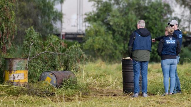 Detectives were also seen examining barrels on the property. Picture: Brenton Edwards