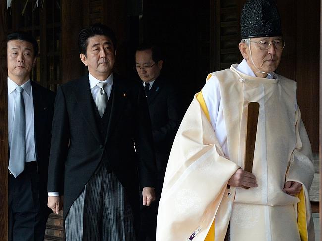 Honouring criminals ... a Shinto priest leads Japanese Prime Minister Shinzo Abe, centre, as he visits the controversial Yasu...