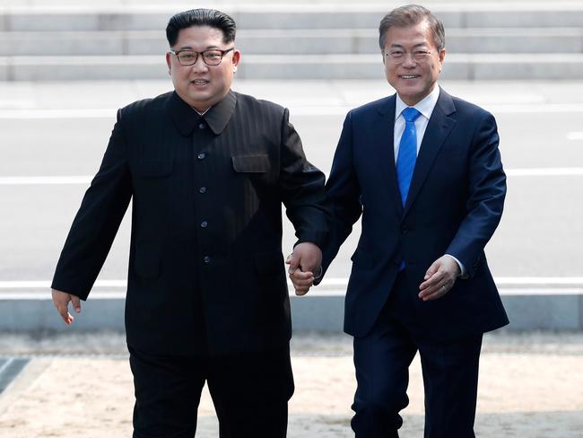 The beaming Korean leaders holding hands in the DMZ has raised hopes there will be peace on the peninsula at last. Picture: Korea Summit Press Pool/AP