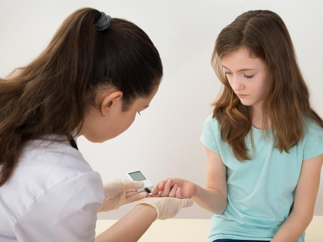 A doctor measures the blood sugar level of a young girl. Picture: iStock