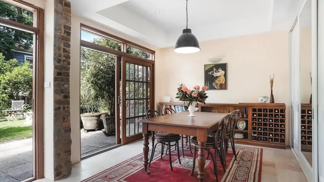 The dining room opens through timber doors to the large yard.