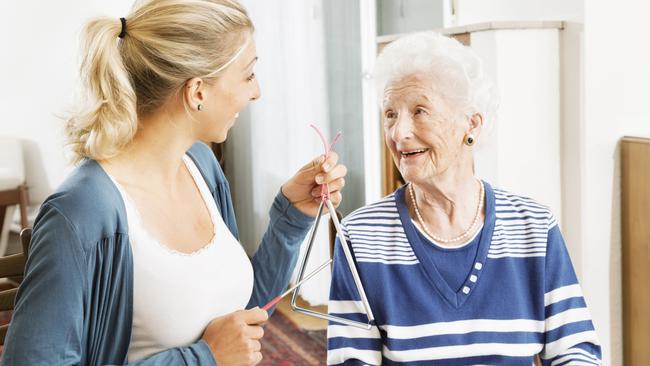 MUSIC THERAPY: Using music can help both those living with dementia, their carers and family members.young therapist playing a triangle to senior woman, music therapy , useful especially for people with Alzheimer disease