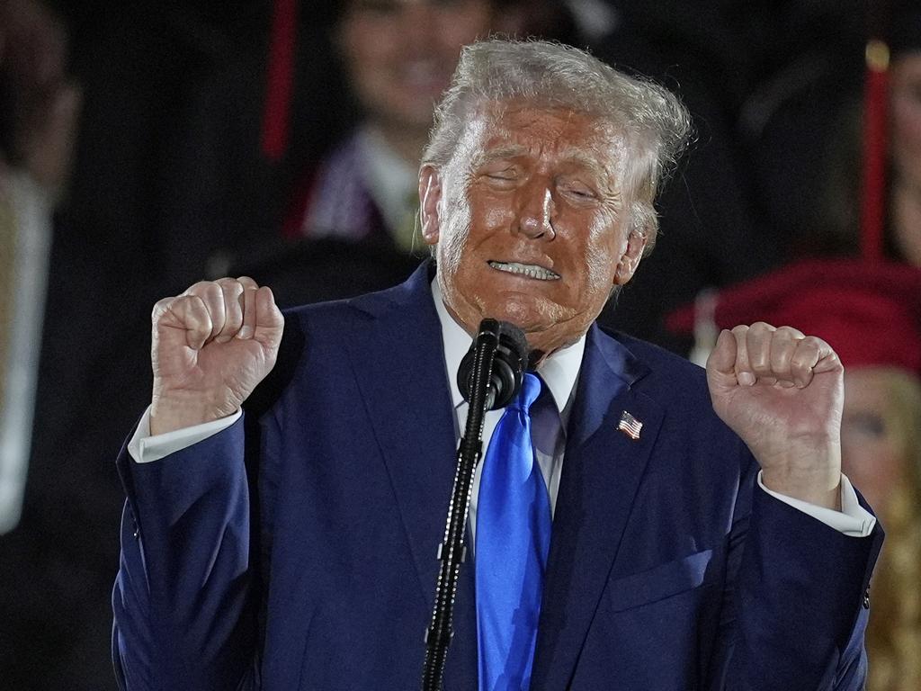 President Donald Trump imitates transgender weightlifters as he gives a commencement address at the University of Alabama. Picture: AP Photo/Mike Stewart