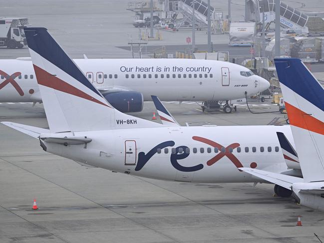 Rex Airlines Boeing 737 planes lay idle on the tarmac at Melbourne's Tullamarine Airport on July 31, 2024. The Australian regional airline Rex cancelled flights as it entered voluntary administration on July 31, leaving the fate of the country's third-largest carrier in serious doubt. (Photo by William WEST / AFP)