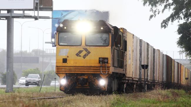 An Aurizon freight train loaded with cargo heads south along the railway tracks at Woree, south of Cairns. Picture: Brendan Radke