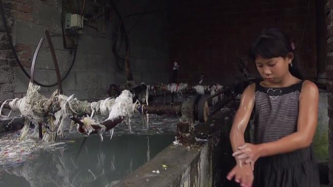 Yi-Jie washes herself with the greying water from the plastic bath.