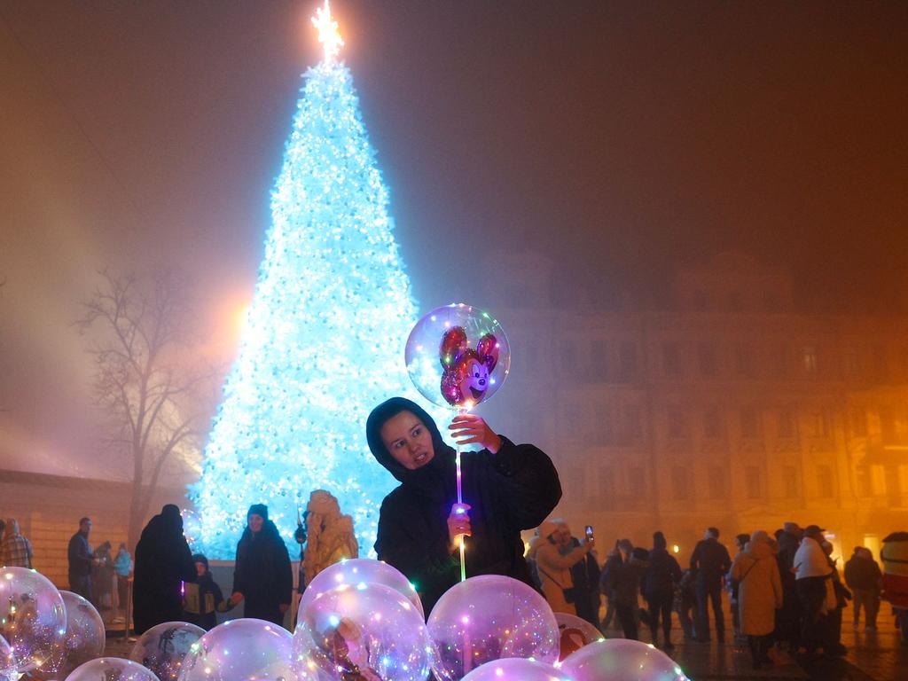 A woman buys an inflatable balloon near the Christmas tree in Sophia Square in Kyiv, on December 24, 2024, amid the Russian invasion in Ukraine. Picture: AFP