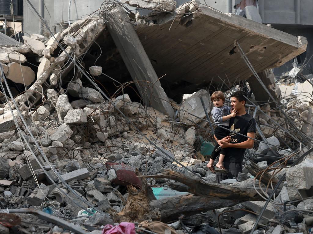 A Palestinian youth holds his younger brother as they stand amid debris of a destroyed building in Rafah, in the southern Gaza Strip. Picture: AFP