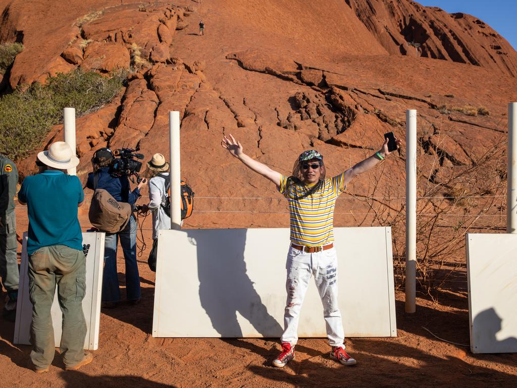 Ken Lee, who climbed Uluru on its last day, in front of dismantled signage Picture: Emma Murray