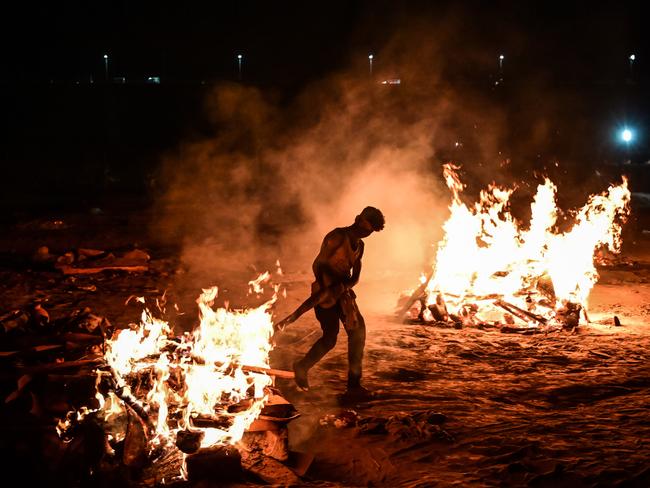 A worker helps cremate the bodies of COVID-19 victims on the banks of the Ganges river. Picture: Ritesh Shukla/Getty Images.