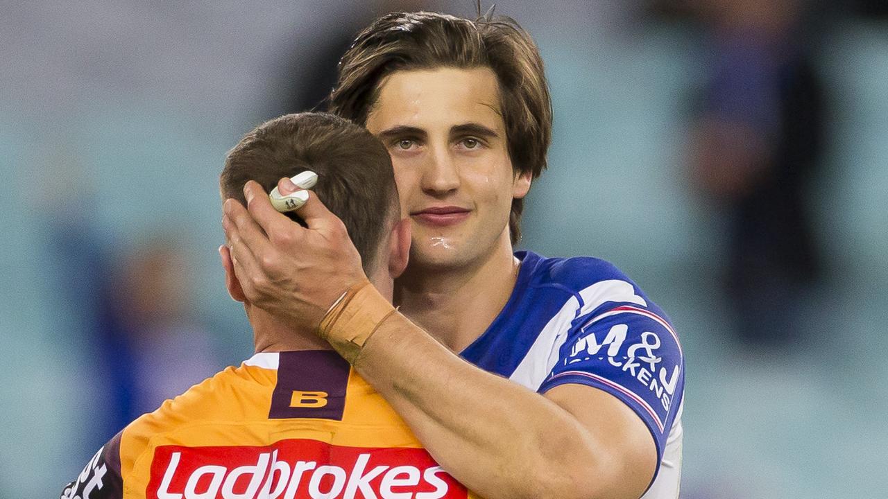 Lachlan Lewis of the Bulldogs hugs Jake Turpin of the Broncos after the Round 25 upset win to Canterbury.