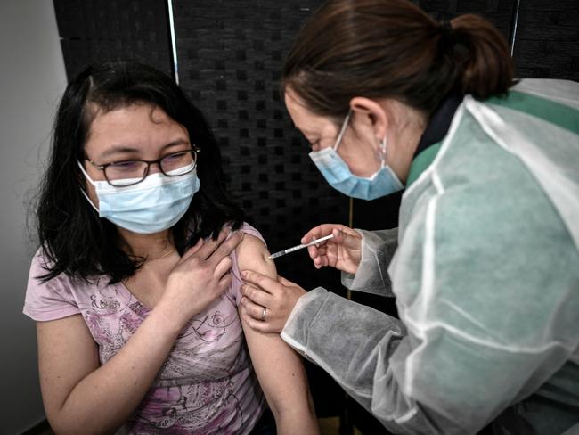 A patient receives a dose of the Pfizer-BioNTech vaccine in Versailles Palace in Versailles, France. Picture: AFP