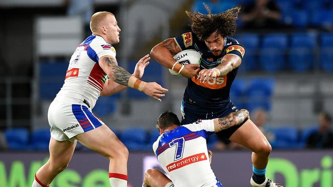 GOLD COAST, AUSTRALIA - SEPTEMBER 25: Kevin Proctor of the Titans is tackled by Mitchell Barnett and Mitchell Pearce of the Knights during the round 20 NRL match between the Gold Coast Titans and the Newcastle Knights at Cbus Super Stadium on September 25, 2020 in Gold Coast, Australia. (Photo by Matt Roberts/Getty Images)