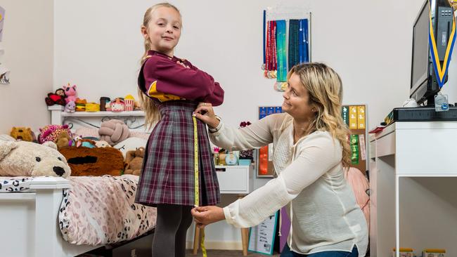 Mum Shelley measures Taliyah's school uniform length. Picture: Jake Nowakowski