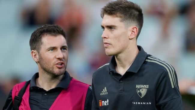 Will Day with a Hawks medico after suffering a concussion in an incident with Paddy Ryder.