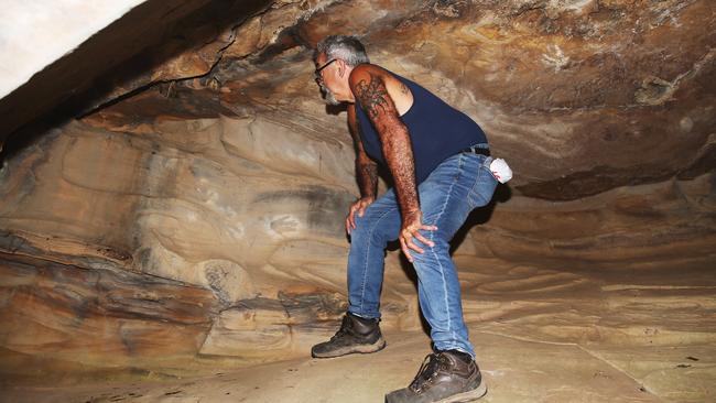 Wonnarua elder Uncle Warren Taggart at one of at least five Hunter Valley caves where thieves have chiselled out indigenous art dating back thousands of years. Picture by Peter Lorimer.