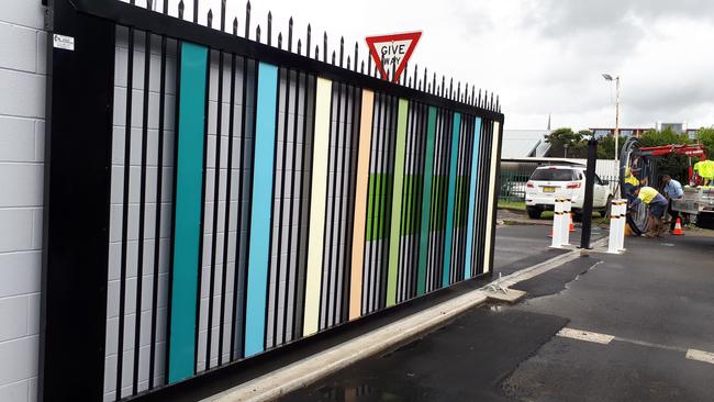 Workers install the front gate of the new perimeter fence. Photo: Janine Watson