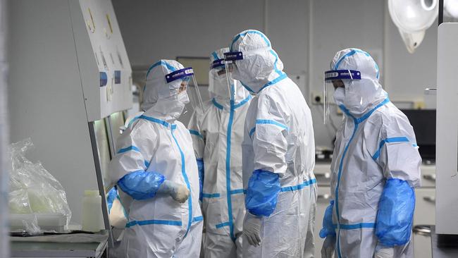 Laboratory technicians work on samples to be tested for the Covid-19 coronavirus at the Fire Eye laboratory in Wuhan, China. Picture: AFP