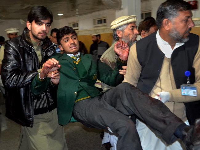 Pakistani volunteers carry a student injured in the shootout at a school under attack by Taliban gunmen. Picture: AP Photo/Mohammad Sajjad