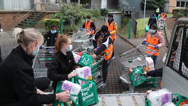 Workers deliver food to one of the locked-down towers in North Melbourne on Tuesday, July 7. Picture: David Crosling