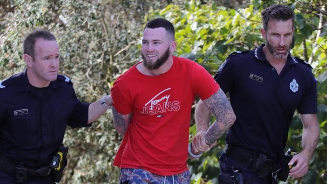 Police lead Kodi Ned Brown away after his arrest. Picture: Glenn Hampson.