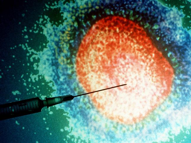 Hypodermic syringe in front of magnified influenza ( flu ) virus.  Generic Medical diseases needle