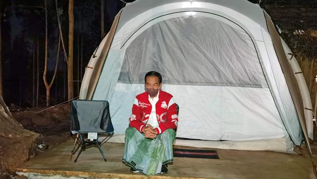 This handout photo taken and released on March 14, 2022 from the Presidential Palace shows Indonesiaâs President Joko Widodo standing next to a tent as he and his entourage camp at a ground in Penajam Paser Utara, where the government plans to move its capital from Jakarta to East Kalimantan. (Photo by AGUS SUPARTO / PRESIDENTIAL PALACE / AFP) / -----EDITORS NOTE --- RESTRICTED TO EDITORIAL USE - MANDATORY CREDIT "AFP PHOTO / Presidential Palace" - NO MARKETING - NO ADVERTISING CAMPAIGNS - DISTRIBUTED AS A SERVICE TO CLIENTS