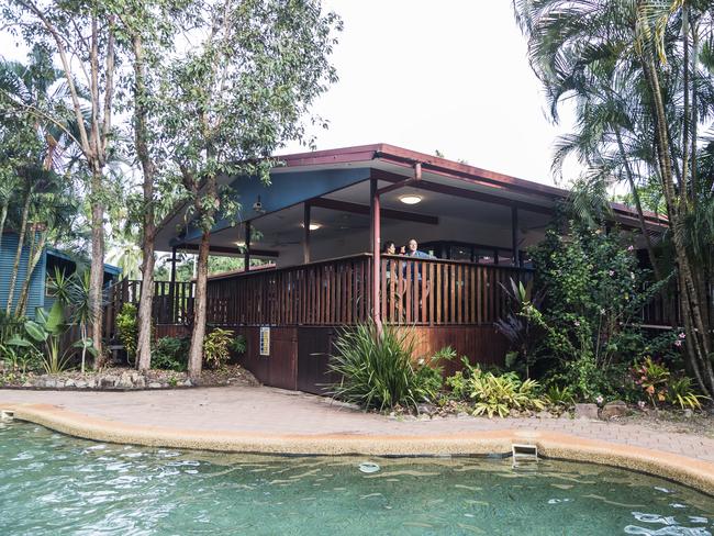 Couple sitting on the balcony of the restaurant, looking out over the pool of the Cape York Peninsula Lodge.