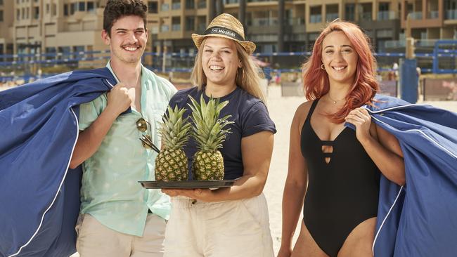 Michael Esterhuizen, Cara Rodgers, and Emily Jones at Glenelg beach, where the Moseley Beach Club has will operate for another four years. Picture: Matt Loxton