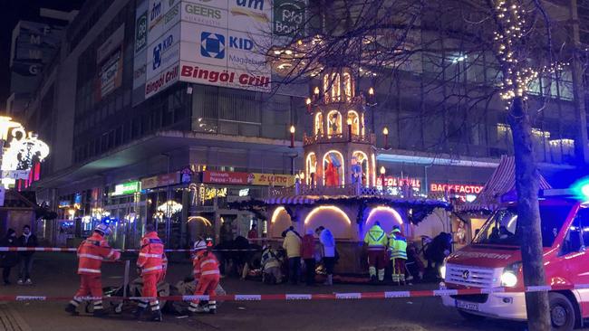 Firefighters and rescue personnel cordon off the area next to a Christmas market, where a car crashed into a crowd injuring dozens of people and killing one. Picture: Doerthe Hein / dpa / AFP