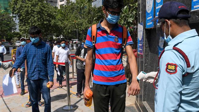 Students get their temperature checked as they arrive to take the Joint Entrance Examination (JEE) Advance test in Noida. Picture: AFP.