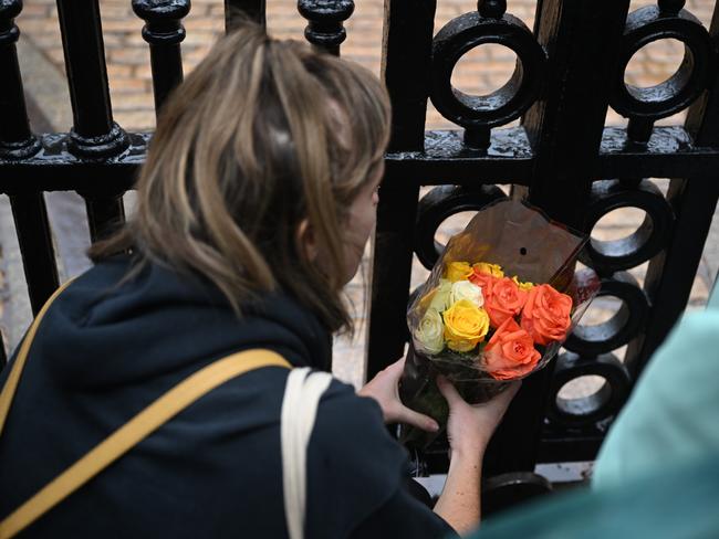 A woman places flowers at the gates of Buckingham Palace. Picture: Getty Images