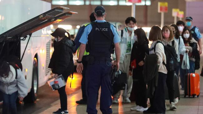 Japanese students escorted to quarantine after arriving on one of the last Qantas flights from Melbourne last night. Picture: Justin Lloyd