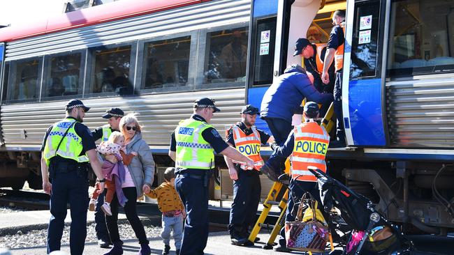 Howard Bartlett is helped down after passing his grand daughter Elsie, 2, and grandson Paddy, 3, down to his wife Ingrid with the help of police at the scene. Picture: Mark Brake