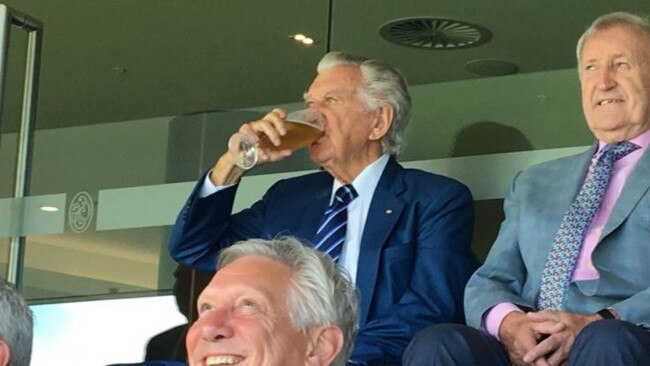 Former Prime Minister Bob Hawke drinks a beer at the cricket.